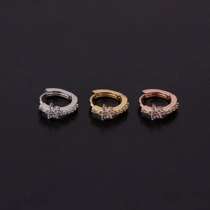 Detailed view of three mini huggie hoop earrings in silver, gold, and rose gold with zircon