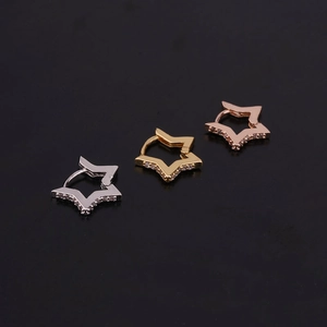 Detailed close-up of star-shaped zircon earrings in silver, gold, and rose gold finishes