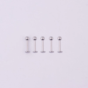 Detailed close-up of five silver 316L stainless steel ball head labret stud piercings