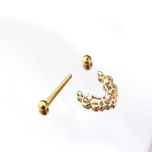 Gold stainless steel nipple ring with crown zircon pendant displayed on white reflective mirror
