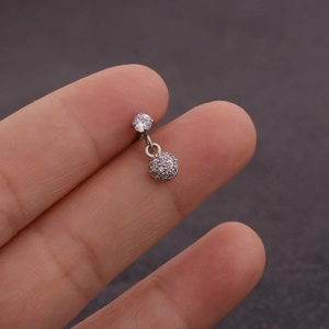 Détail d'un clou d'oreille en acier inoxydable avec griffe en zircon et boule pavée