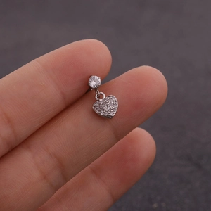 Gros plan d'une boucle d'oreille cœur en zircone montrant la taille réelle