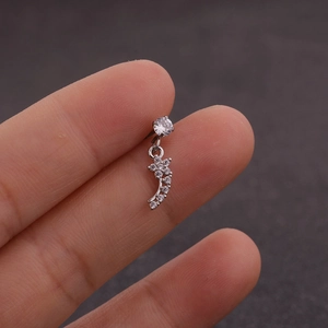 Vue macro d'un clou d'oreille fleur en zircone tenu à la main pour montrer sa petite taille