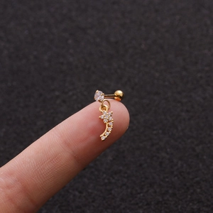 Détail macro d'un piercing cartilage doré avec pendentif lune et oxydes de zirconium