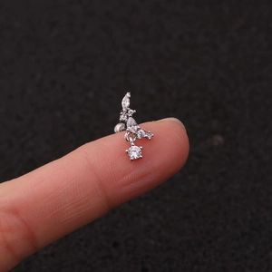Primo piano di un piccolo orecchino a fiore in argento con pietre di zirconia