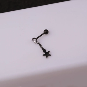 Gros plan d'un clou d'oreille noir en acier inox avec pendentif étoile et zircon