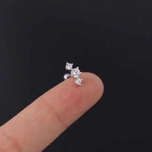 Macro shot of 20G stainless steel screw back ear studs with three clear cubic zirconias