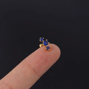 Close-up of a gold 20G surgical steel earring with three blue cubic zirconia clusters
