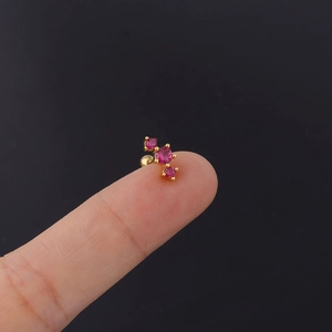Macro shot of 20G stainless steel helix stud with three pink zircons on a golden post