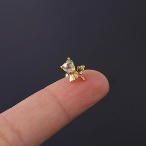 Close-up of heart-shaped bat wing tragus stud with iridescent stone on a finger