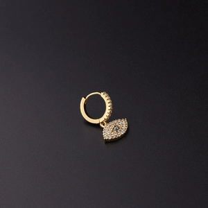 Detalle de pendiente ojo turco dorado con pavé de circonitas azules sobre fondo negro
