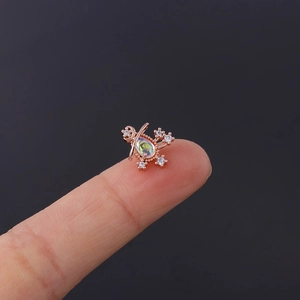 Detailed close-up of rose gold moonstone cartilage earring showing small size on fingertip