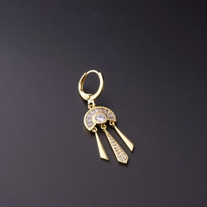 Macro shot of gold huggie earring featuring a crystal crescent and polished metal spikes