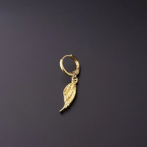 Detailed close-up of a golden wing pendant earring with intricate feather textures