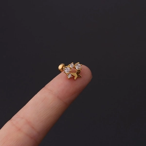 Golden butterfly cartilage stud with cubic zirconia shown on a fingertip for size