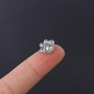Detailed close-up of opal cat paw stud earring on finger showing its tiny miniature size