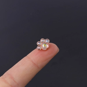 Macro view of rose gold cat paw stud earring with opal stones on a fingertip