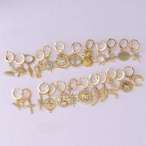 Detailed grid of gold hoop earrings with crystal micro-pave butterfly and star charms