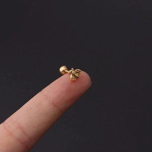 Detailed macro view showing the fine golden bee wing texture on a 16g steel piercing