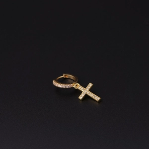 Macro detail of gold cross hoop earring with white crystal pave setting on black background