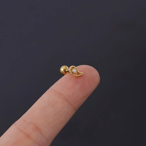 Detailed macro view of gold 16G screw back stud earring with clear zircon inlay