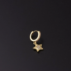 Detalle de pendiente de estrella dorada con micro pavé de circonita en fondo negro