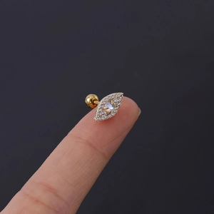 Macro view of gold Evil Eye cartilage stud with white zircon and moonstone inlay
