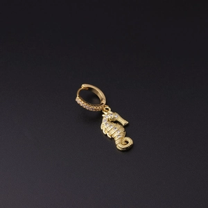 Detailed close-up of a gold seahorse earring with micro-pave crystals on dark background