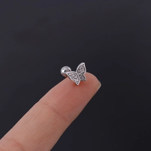 Detail shot of silver butterfly tragus stud with clear zircon and screw ball back
