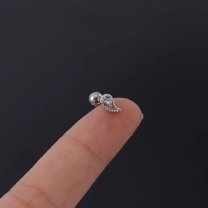 Close-up of 16G silver leaf stud earring with micro-paved zircons on a fingertip