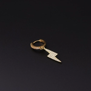 Macro detail of lightning bolt earring with micro-pave white zircon in golden finish