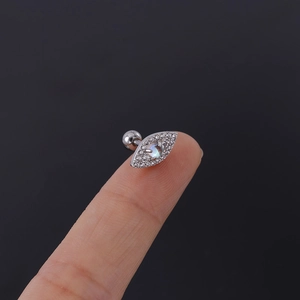 Detail of evil eye cartilage stud with moonstone and pavé crystals on fingertips