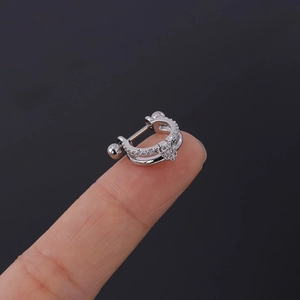 Détail d'un petit piercing double anneau argenté avec zircons posé sur le bout d'un doigt