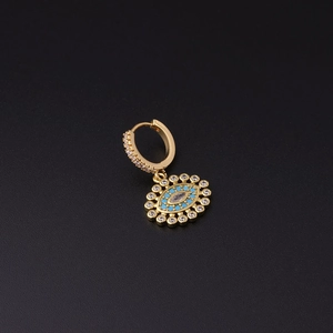 Macro shot of gold huggie hoop earring with micro-paved evil eye pendant on black base