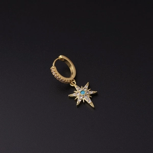 Detail of gold star-shaped hoop earring featuring blue bead and pave cubic zirconia stones