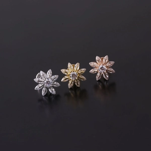 Dettaglio di piercing labret 16G in acciaio inossidabile con fiori in zircone in tre metalli