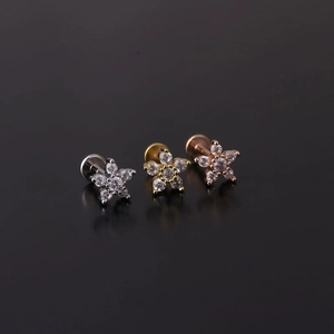 Dettaglio di piercing labret a stella 16G in acciaio con zirconi in tre varianti colore