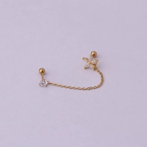 Detailed view of golden double-piercing chain earring with a sparkling flower and crystal