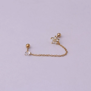 Detailed macro view of the gold chain linking a stud and a crystal petal flower earring