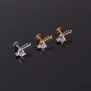 Macro shot of three heart-shaped zircon labret studs in silver, gold, and rose gold finishes