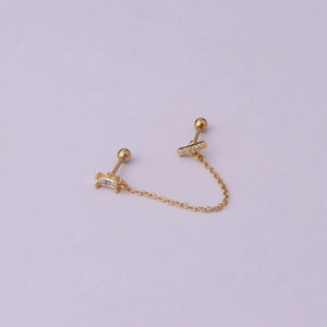 Detailed close-up of gold chain earrings with cubic zirconia and screw ball backs