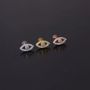 Detail view of silver, gold, and rose gold evil eye labret studs with micro zircon inlays