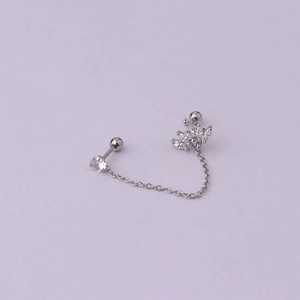 Macro detail of silver stainless steel chain earring with sparkling zircon crown stud