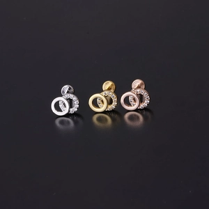 Detail showing gold, silver, and rose gold labret studs with interlocking zircon rings