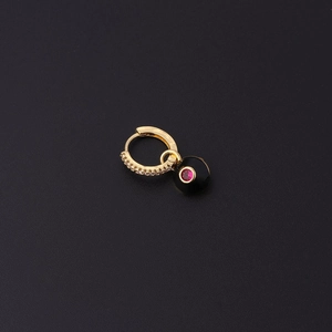 Gros plan détaillé d'une boucle d'oreille en or avec zircon et pendentif œil émaillé