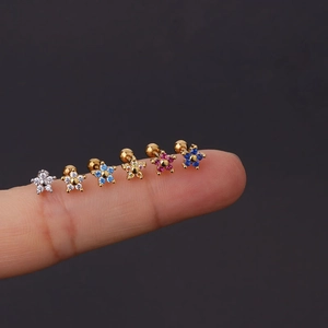Close-up of small flower earrings with colorful crystals and screw ball backs on fingers