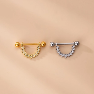 Dettaglio di piercing per capezzoli con ali di zircone marquise in oro e argento lucido