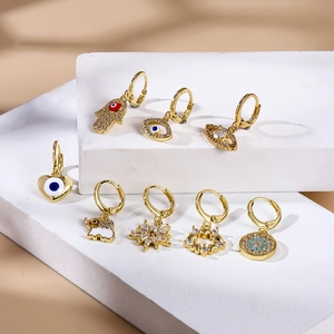 Set de 8 pendientes dorados con colgantes de ojo turco y mano de fátima