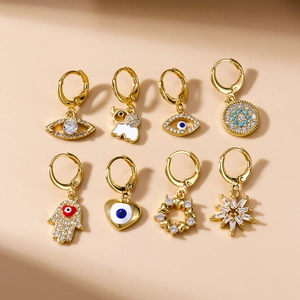 Set de ocho pendientes dorados con ojo turco y mano de Fátima decorados con circonitas