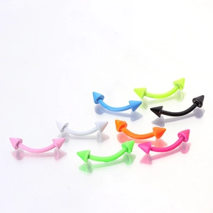 Macro shot of colorful neon lacquer curved barbells with sharp cone ends for eyebrow piercing